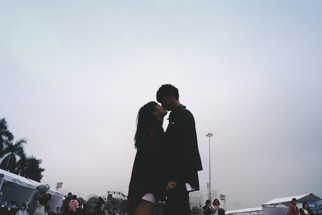 Paare Hintergrundbild 1125x750. Paar, Das Zusammen Küsst, Das Nahe Leuten Steht · Kostenloses Stock Foto