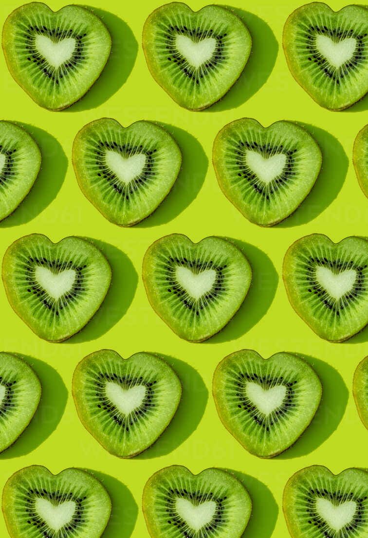 Herzen Hintergrundbild 756x1106. Herzförmige Kiwi Fruchtscheiben Muster Auf Grünem Hintergrund, Lizenzfreies Stockfoto