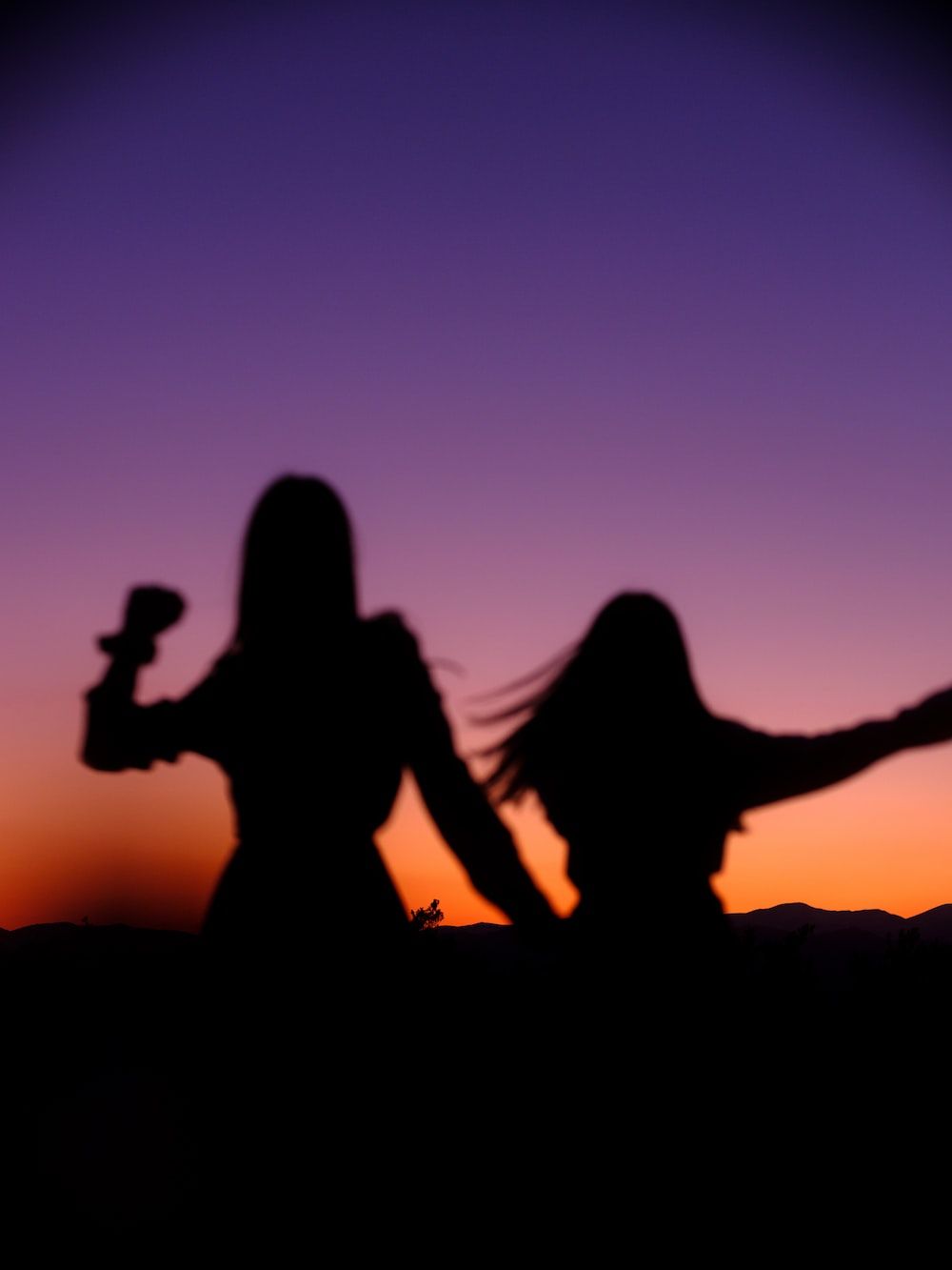 Freundschaft Hintergrundbild 1000x1333. Foto zum Thema Silhouette von 2 Frauen, die während des Sonnenuntergangs auf Felsen sitzen