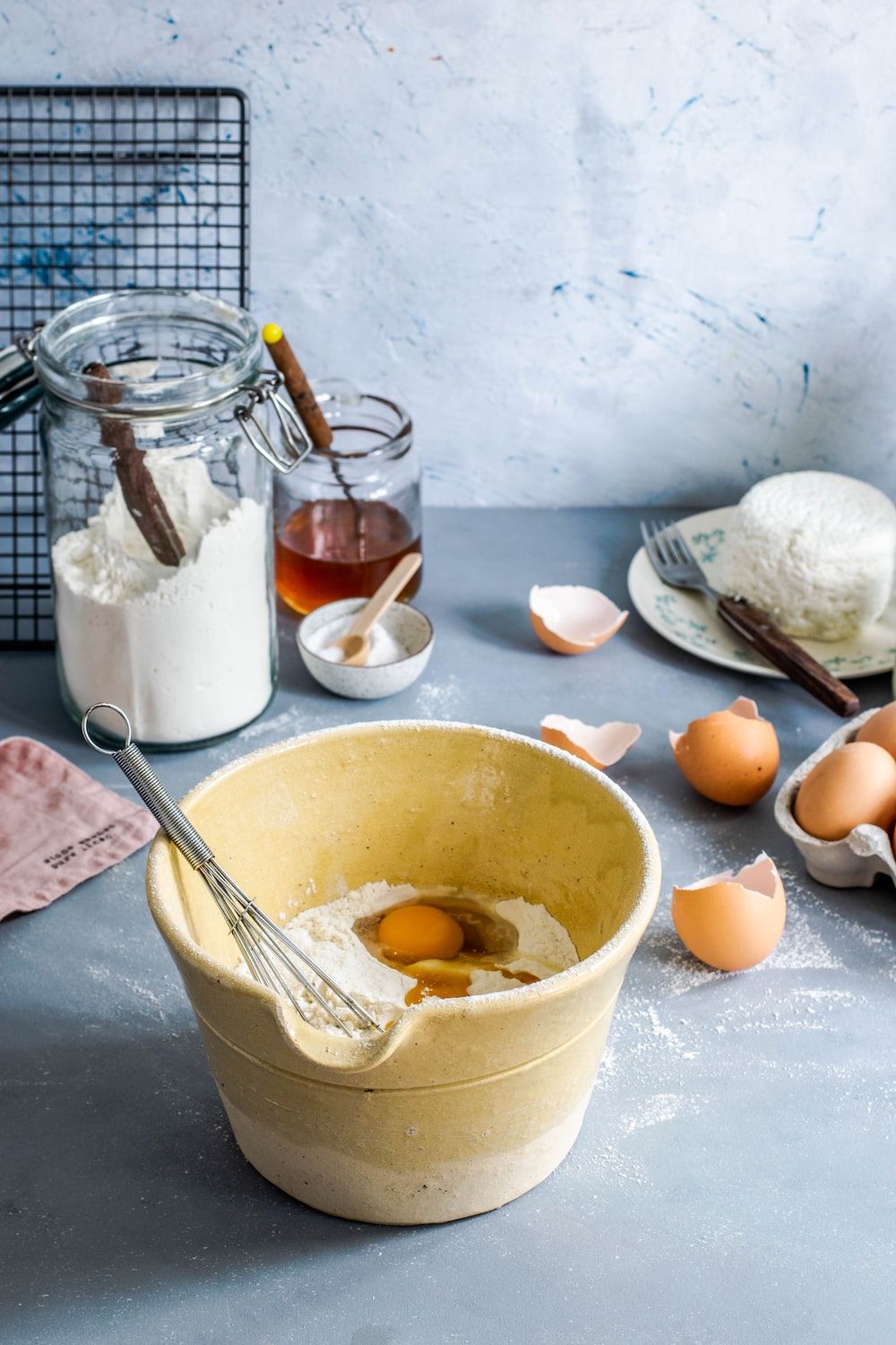  Mehl Hintergrundbild 1000x1500. Foto zum Thema braune Rührschüssel mit Eiern und Mehl mit Schneebesen