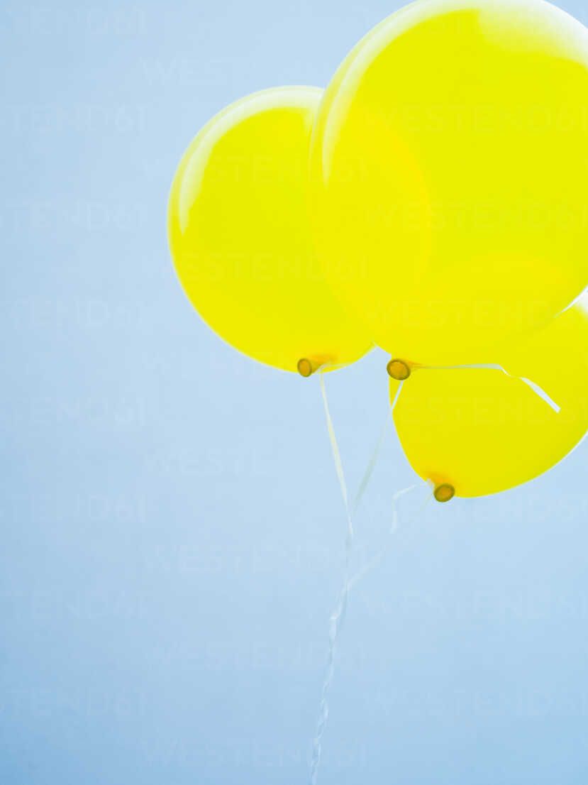 Luftballons Hintergrundbild 829x1106. Deutschland, München, Gelbe Luftballons gegen blauen Himmel, lizenzfreies Stockfoto