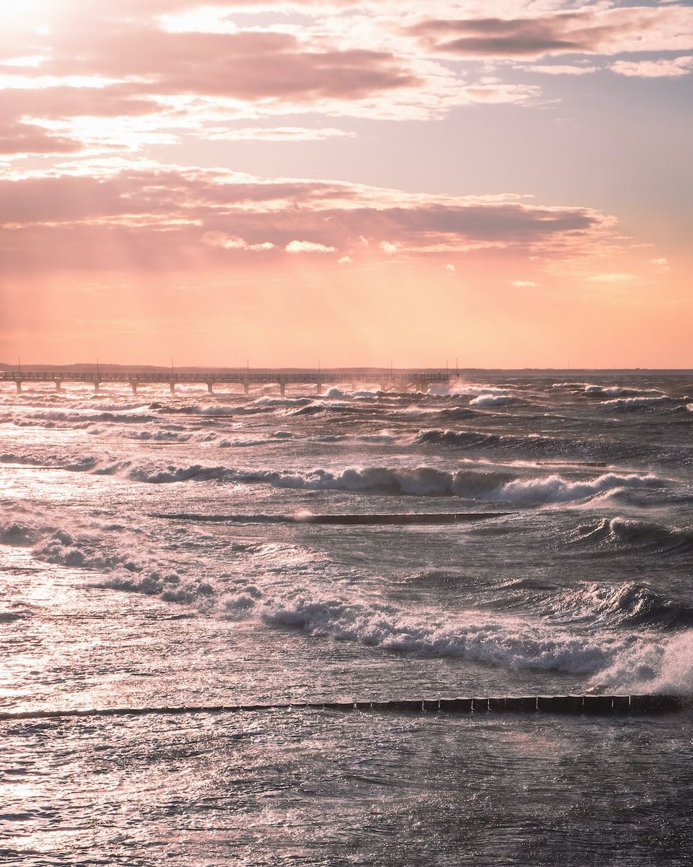  Ostsee Hintergrundbild 1000x1250. Foto zum Thema Meereswellen, die bei Sonnenuntergang an Land stürzen