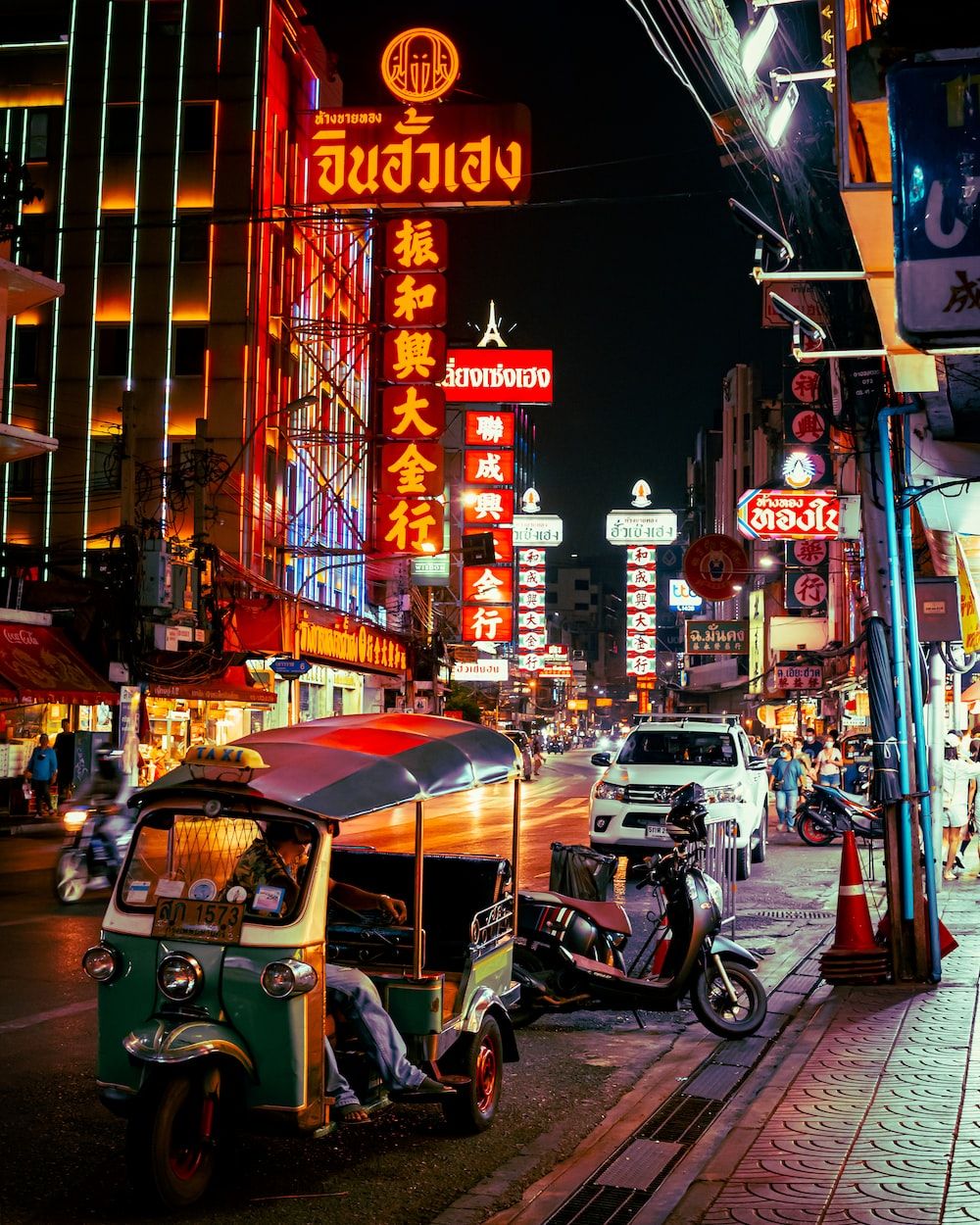  Thailand Hintergrundbild 1000x1250. Foto zum Thema Eine straße mit leuchtreklamen und rollern