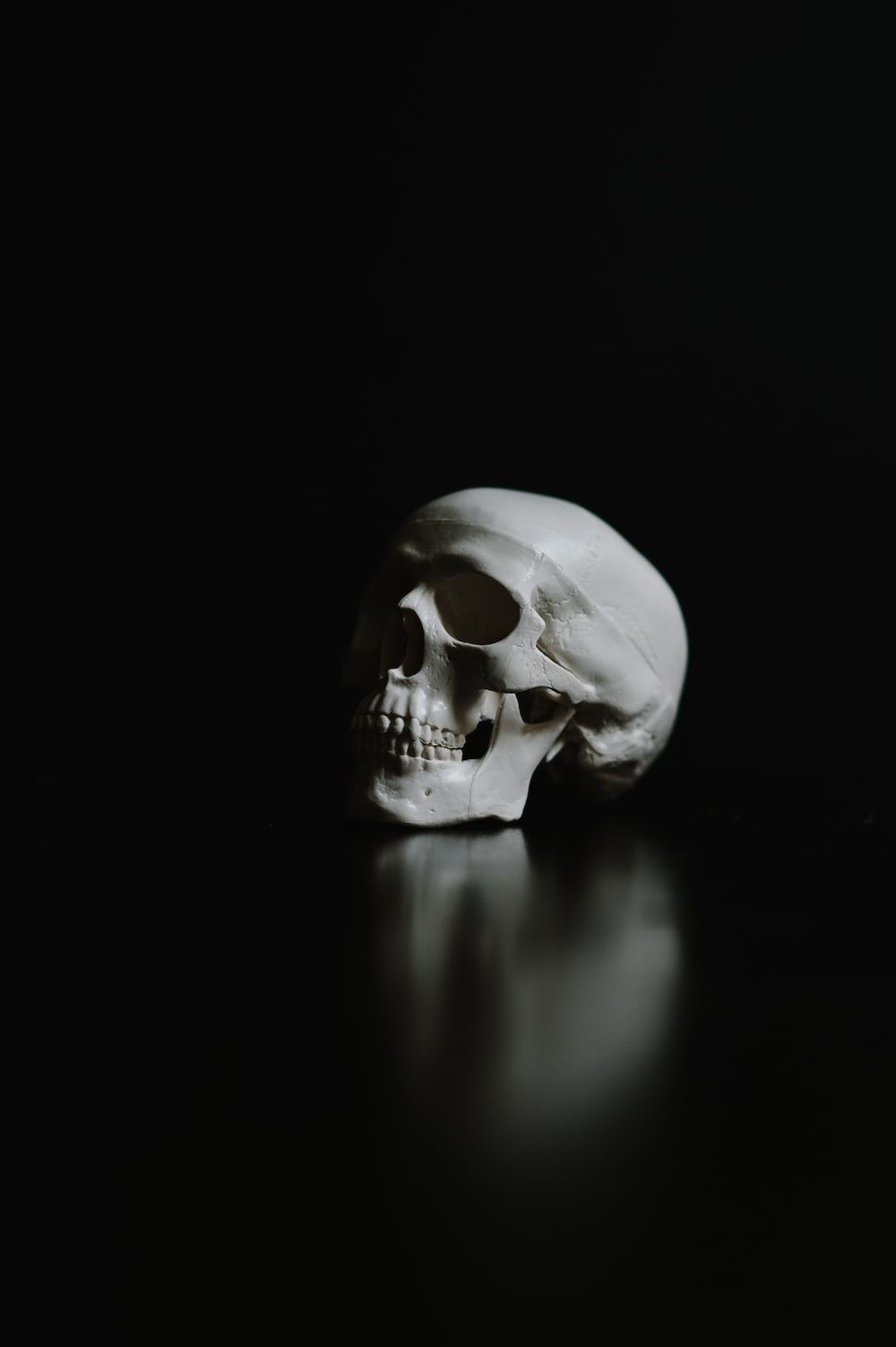  Totenkopf Hintergrundbild 1000x1503. Foto zum Thema Ein weißer menschlicher schädel auf schwarzem hintergrund