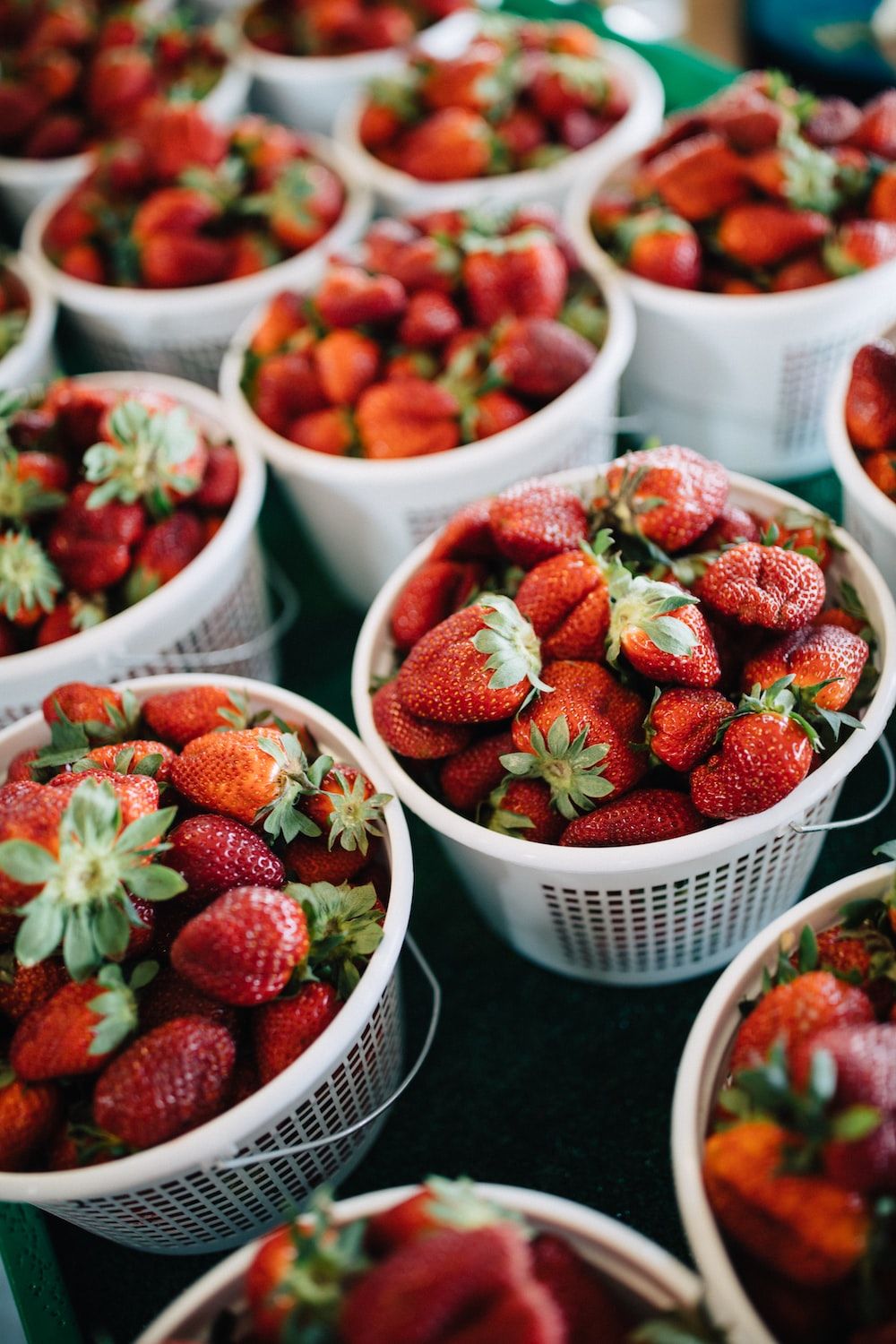  Erdbeeren Hintergrundbild 1000x1500. Foto zum Thema Körbe mit Erdbeeren sitzen auf einem Tisch