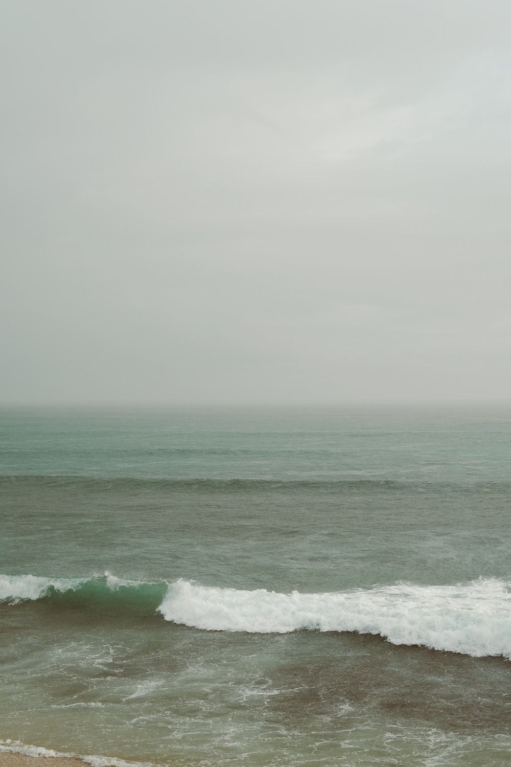  Wellen Hintergrundbild 1000x1500. Foto zum Thema Wellen am Strand