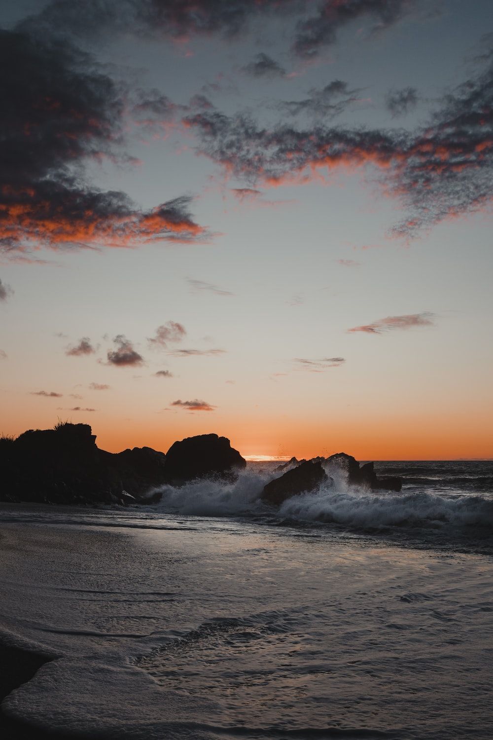  Sonne Strand Meer Hintergrundbild 1000x1500. Foto zum Thema Die Sonne geht über dem Meer und den Felsen unter