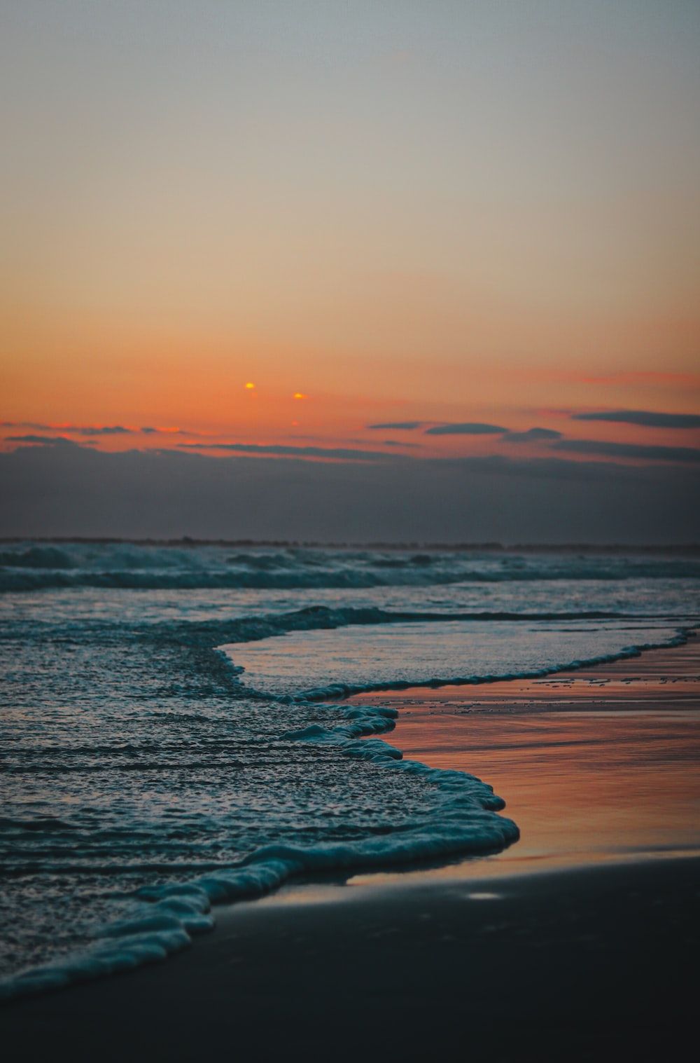  Sonne Strand Meer Hintergrundbild 1000x1517. Foto zum Thema Die Sonne geht über dem Wasser am Strand unter