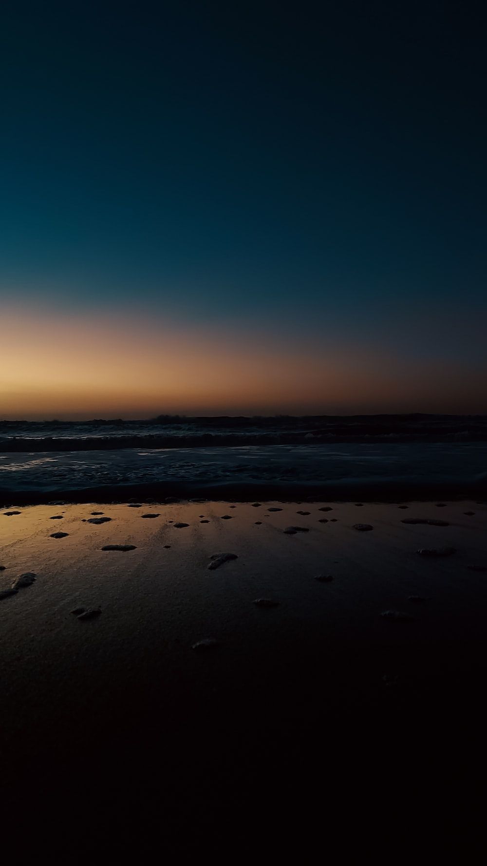  Sonne Strand Meer Hintergrundbild 1000x1776. Foto zum Thema Die Sonne geht am Strand unter, im Hintergrund das Meer