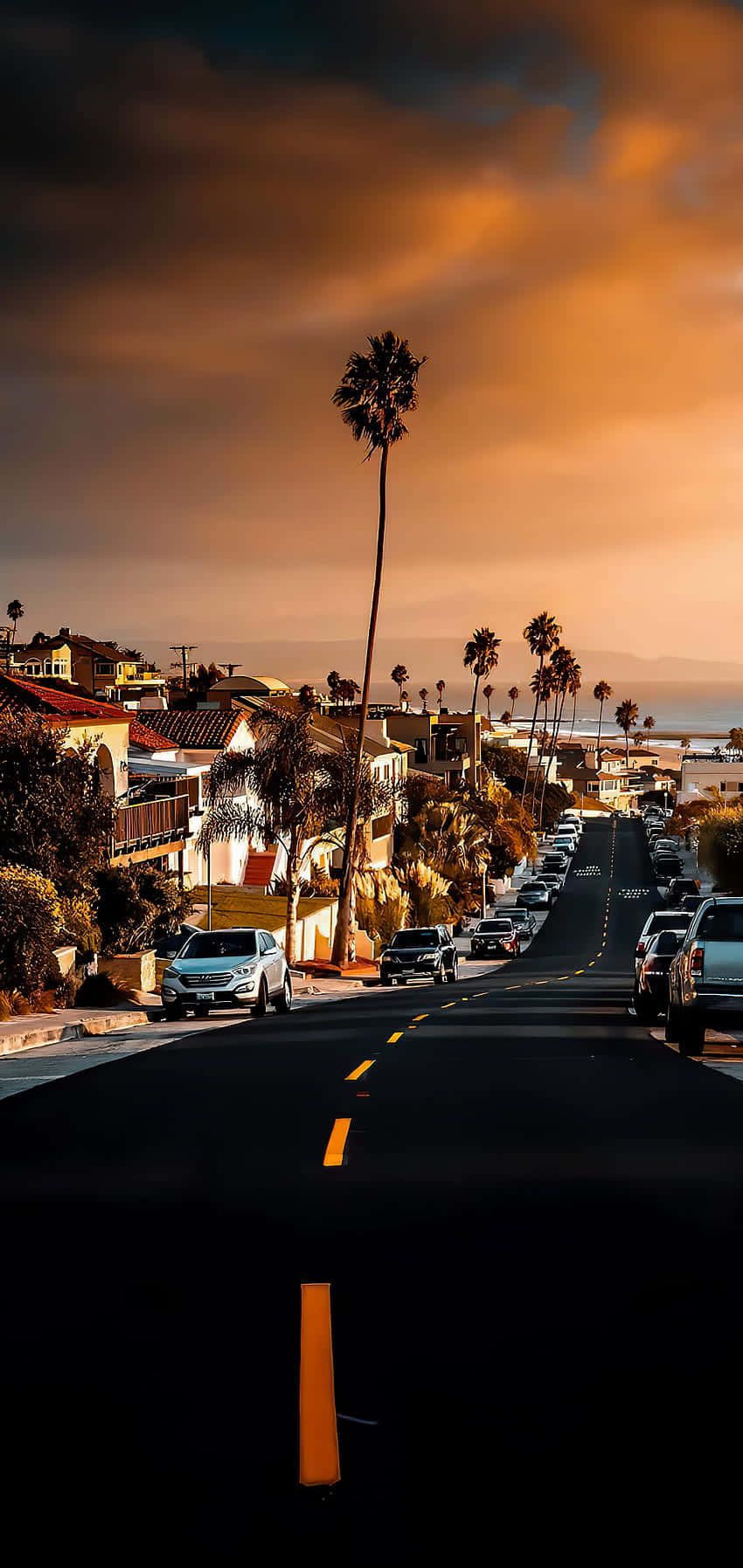  California Hintergrundbild 850x1795. Download A Street With Palm Trees And Cars At Sunset Wallpaper