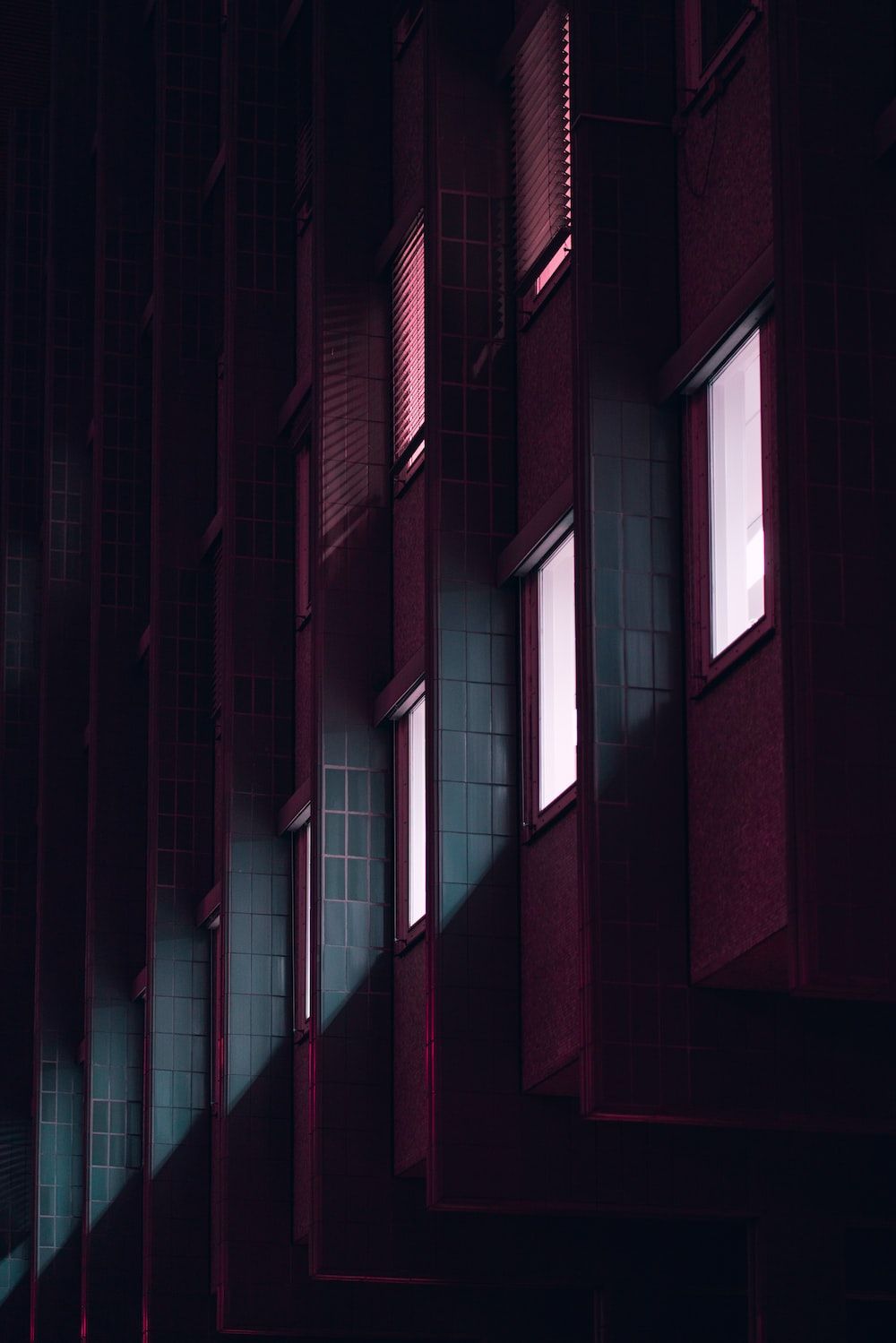 Gebäude Hintergrundbild 1000x1499. Foto zum Thema Eine Fensterreihe in einem dunklen Gebäude